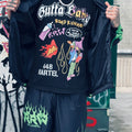 A person holding a black t-shirt with 'GUTTA BABY' and 'ROADRUNNER' text and graphics. neighborhood supplier rrw x gutta baby streetwear tee